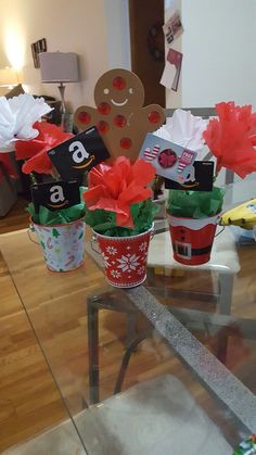 three flower pots with paper flowers in them and a gingerbread cutout on top