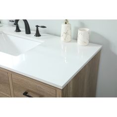 a bathroom vanity with two sinks and soap dispensers