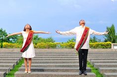 two people standing on steps with their arms outstretched