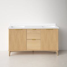 a wooden cabinet with two sinks on top of it in a white walled room next to a wall