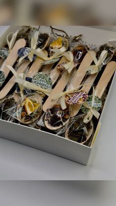 a box filled with wooden spoons and wrapped in cellophane wrapper on top of a table