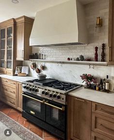 a stove top oven sitting inside of a kitchen next to wooden cabinets and counter tops