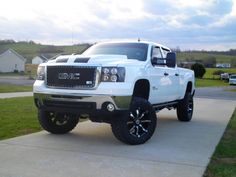 a white truck parked on top of a driveway