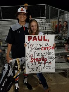 two people standing next to each other holding a sign that says paul you're a great catch