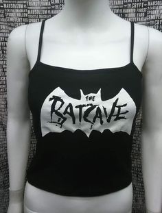 This is a black The Batcave crop tank top with spaghetti straps. This has a Batcave image screen printed on the front. 57% cotton/ 38% polyester/ 5% SpandexThese are handmade screenprinted and slightly vary from the photo. Please feel free to email me any questions. Thanks for looking.Due to an influx of incorrect addresses if a package is returned,  you must pay the shipping cost to resend the item to you.I do not do exchanges and I do not take returns unless the item is damaged. I thoroughly c Edgy Black Tank Top For Halloween, Punk Black Tank Top For Halloween, Punk Style Black Tank Top For Halloween, Fitted Black Crop Top Band Merch, Fitted Black Emo Tank Top, Black Fitted Grunge Tank Top, Fitted Black Emo Style Tank Top, Black Sleeveless Punk Crop Top, Fitted Punk Style Cotton Crop Top