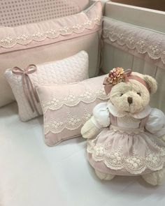 a teddy bear sitting next to two pillows