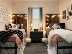 two twin beds in a bedroom with lights on the wall above them and rugs