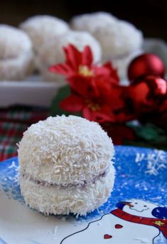 a plate topped with white chocolate covered donuts next to red and green christmas decorations