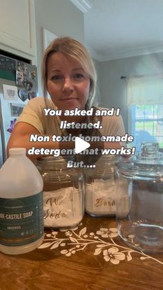 a woman sitting at a kitchen counter with jars on the counter and an ad about her