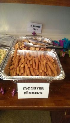 there are several trays of food on the table and one is filled with finger foods