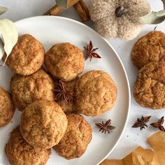 a white plate topped with cookies and anise on top of a table next to a teddy bear