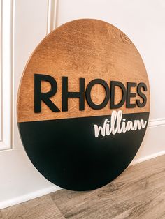 a wooden sign that says rhodes william on the side of a wall next to a door