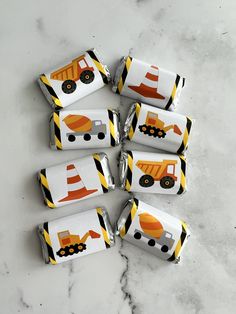 six construction themed candy wrappers sitting on top of a marble counter