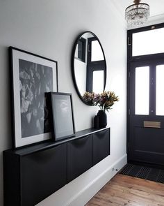 a black and white entryway with two framed pictures on the wall next to it