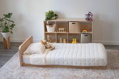 The oak montessori floor bed with one headboard and a six cube shelf in the background Low Floor Bed, Floor Bed Toddler, Wooden Toddler Bed, Room Sharing, Modular Bed, Low Profile Bed Frame, Kid's Bed, Toddler Floor Bed, Floor Bed Frame