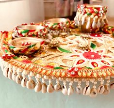 a decorative tray with shells and beads on it