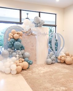 balloons and decorations are on the floor in front of a large window at an event