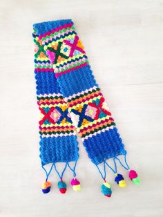 a colorful knitted scarf with pom poms