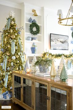 a decorated christmas tree sitting in the corner of a living room next to a china cabinet