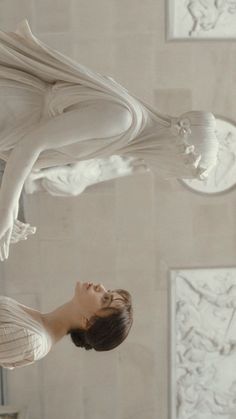 a woman standing in front of a white sculpture