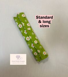 a green umbrella with white flowers on it and the words standard & long sizes below