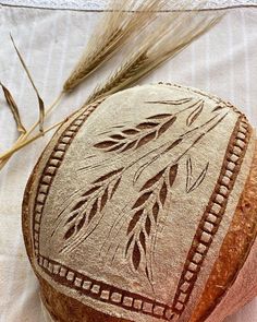 a loaf of bread sitting on top of a table next to some ears of wheat