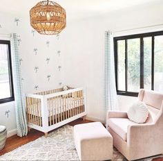 a baby's room with a crib, chair and window