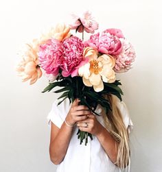 a woman holding a bunch of flowers in her hands