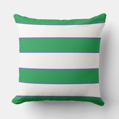 a green and white striped pillow sitting on top of a wall