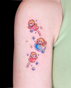 a woman with a small tattoo on her arm that has two little cartoon characters flying through the sky