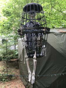 a skeleton in a cage with chains hanging from it