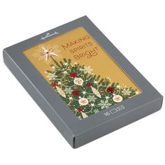 a boxed christmas card with an image of a tree and star on the front in grey