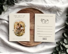 two wedding cards sitting on top of a wooden plate