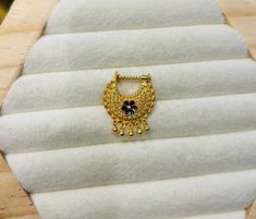 a close up of a piece of jewelry on a white cloth with gold chains and beads