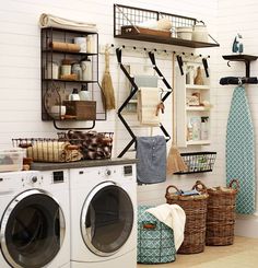 an image of a laundry room with clothes hanging on the wall and other items in baskets