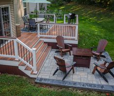 a deck with chairs, table and grill on it