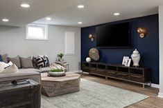 a living room filled with furniture and a flat screen tv mounted to the side of a wall