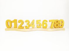 the numbers are yellow in color, and they appear to be carved from wood or plywood