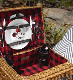 a picnic basket with mickey mouse plates and utensils