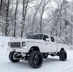 a white truck driving down a snow covered road