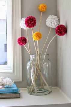 a vase filled with flowers sitting on top of a white shelf next to a window