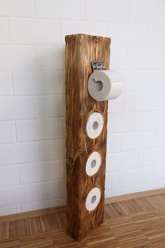 a toilet paper dispenser made out of wood with rolls of toilet paper on it