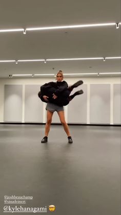 a woman is dancing in an empty room