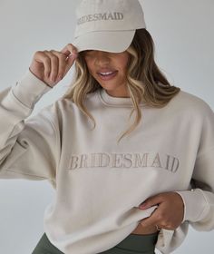 a woman wearing a bridesmaid hat and sweatshirt