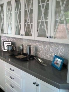 a kitchen with white cabinets and black counter tops