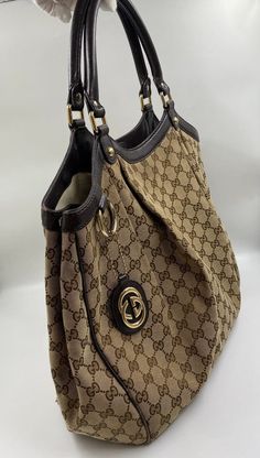 A Gucci GG canvas tote with brown leather trim. The perfect go anywhere, chuck it all in tote. The bag is lined with a cream cotton lining and there is an interior slip pocket for valuables. This bag comes with the original Gucci dust bag, Gucci ity cards and even the original receipt. The bag is in overall good condition. Some wear can be seen on the leather binding and some small pulls in the canvas. There are some further marks and pen marks on the lining. Leather Binding, Bag Gucci, Gold Ounce, Vuitton Bag, Diaper Backpack, Exclusive Bag, Casual Backpack, Large Tote, Bag Tags