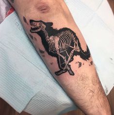 a man's arm with a skeleton and a dog tattoo on the left forearm