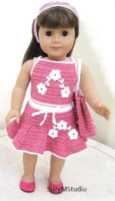 a crocheted doll wearing a pink dress and headband