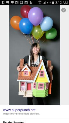 a woman holding a house with balloons above her head