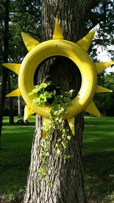 a tree with a yellow tire hanging from it's trunk